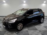La voiture noire est garée sur un sol en carrelage à damier.
