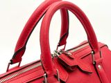 a red handbag with a metal handle on a white background