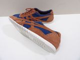 brown and blue sneakers with white soles on a white surface