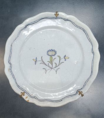 une assiette blanche ornée d'une fleur bleue et jaune