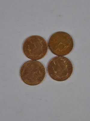 three gold coins sitting next to each other on a white surface