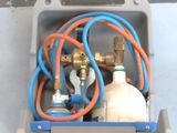 a box that has a bunch of gas bottles and hoses in it