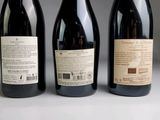 three bottles of wine sitting on top of a table next to each other