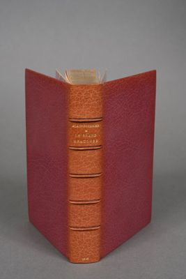 an orange book sitting on top of a table next to a gray wall