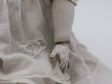 a close up of a doll with a white dress on