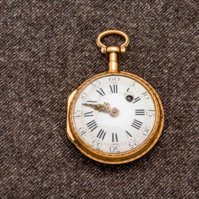 une montre de poche en or avec des chiffres romains