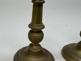 pair of antique brass candlesticks on a white background