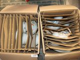 beaucoup d'assiettes dans une boîte posée par terre