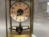 a clock that is in a glass case on a table