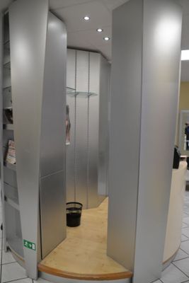 Tour formant banque en bois stratifié beige et gris.