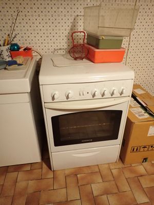 un four de cuisine blanc posé à côté d'une machine à laver