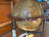 a large globe sitting on a wooden stand in a living room