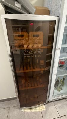 un réfrigérateur avec une porte vitrée dans lequel se trouvent des aliments