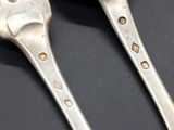 two spoons and a fork with holes on them