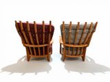 pair of wooden chairs with red cushions on a white surface