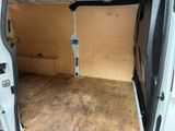 a small white van with the door open in a garage