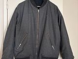 grey and black jacket hanging on a white door with a blue hanger