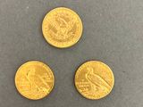 three different types of gold coins on a gray surface