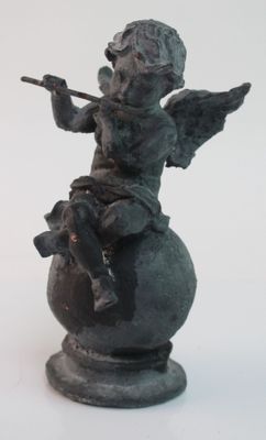 a statue of an angel sitting on top of a ball