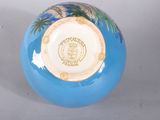 a blue vase with a picture of a palm tree on it