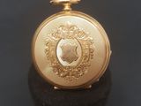 an image of a gold pocket watch sitting on top of a black surface