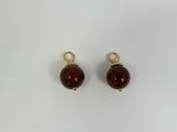 a pair of red glass beads on a white background