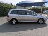 a silver car parked in a parking lot with a blue canopy