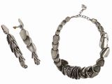 une photo d'un ensemble composé d'un collier et d'un bracelet en argent sur fond blanc