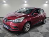 une voiture rouge est garée dans une pièce au sol en damier