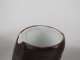 a brown and white cup sitting on a table