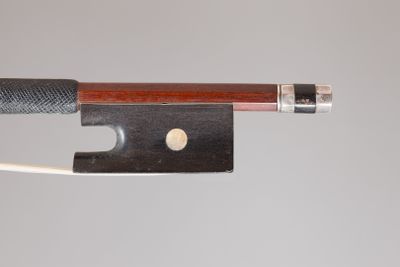 un gros plan d'un archet de violon auquel est attaché un morceau de corde