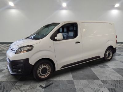 la camionnette blanche est garée dans une grande pièce au sol en damier