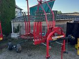 a red cart that is sitting in the gravel