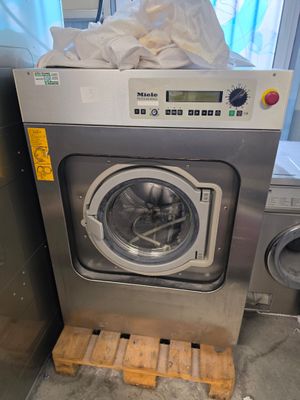 une photo d'une machine à laver dans une buanderie