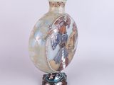 a vase with a picture of a woman on it on a stand