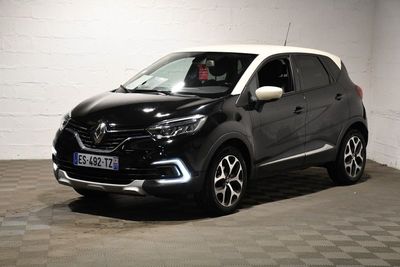 La voiture noire et blanche est garée dans le garage.