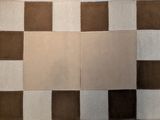 un tapis en patchwork marron et blanc posé sur une table blanche