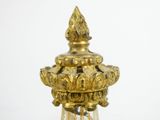 a glass vase with a gold decoration on top of it