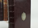a brown leather book with a gold medallion on it