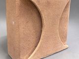 a brown vase that has a curved design on it