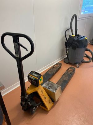 une photo d'une pièce où se trouvent un chariot élévateur et un aspirateur