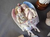 a figurine of two children in a shell on a table