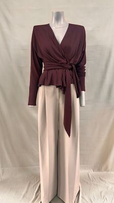 une photo d'un mannequin portant un haut bordeaux et un pantalon beige