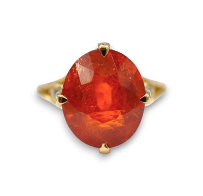a close up of a ring with a red stone in it