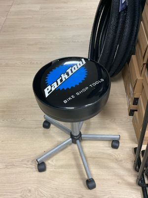 un tabouret noir posé sur un parquet