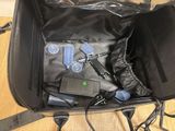 a black bag with electronics inside of it on the floor