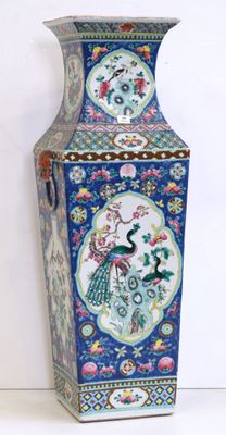 a blue vase with a peacock on it sitting on a table