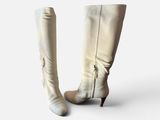 pair of white leather boots on a white surface with a white background