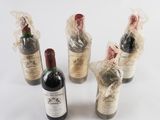 four bottles of wine wrapped in plastic wrap on a white surface