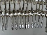 a lot of spoons that are hanging on the wall